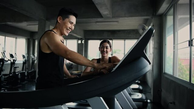 Fitness concept of 4k Resolution. Asian man and woman talking while exercising in the gym.
