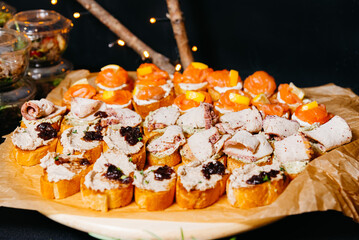 finger food, catering concept - close up of delicious bruschetta with turkey meat, tuna canapes...