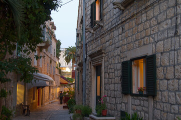 small walkway or alley with historic stone buildings in Hvar, Croatia in late afternoon - obrazy, fototapety, plakaty