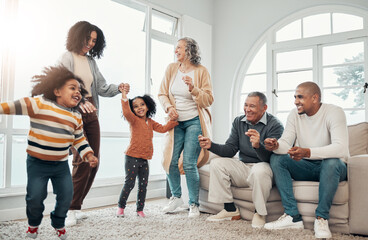 Big family, children dancing and living room with parents, grandparents or love with holding hands in home. Girl kids, mom and dad with cheerful dance, smile or happiness in house together on holiday