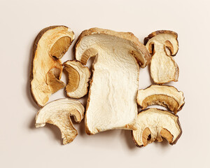 Minimal food pattern beige monochrome colored from dried slices of porcini, dehydrated food boletus mushrooms, top view, aesthetic flat lay. Natural forest white mushroom, healthy vegetarian eating