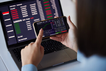 Stock trading chart, laptop and phone in hands of woman for crypto, data analysis and bitcoin screen. Fintech growth, ecommerce and girl on technology for financial statistics, profit and investment