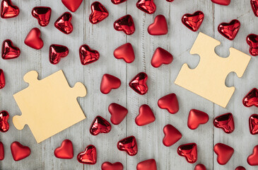 Little red hearts and wood puzzle pieces simulate a single people on white wood background. Unmarried  people looking for love concept.