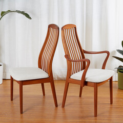 Mid-century modern wooden dining room chairs. Back-to-back view in front of long white curtains...