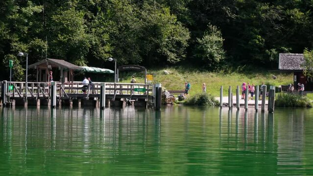 People waiting at Salet landing stage at Koenigssee Berchdesgaden Bavaria Germany. Sunny Summerday. Shot from boat view