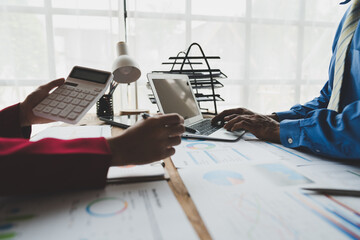 Group of businessmen, investors brainstorm to analyze financial report situation Calculate...