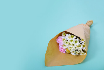 Ramo de flores, margaritas blancas y claveles rosa sobre fondo azul baby con espacio para texto ideal para banner de florerías 