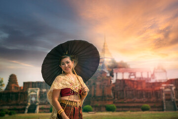 beautiful asian woman holding bamboo umbrella standing against old temple in ayutthaya world heritage site of unesco thailand ,