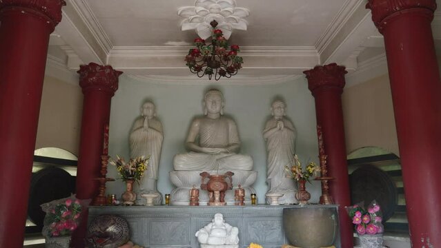 White Buddha Inside The Prayer Hall Of Temple In Vietnam. - tilt down