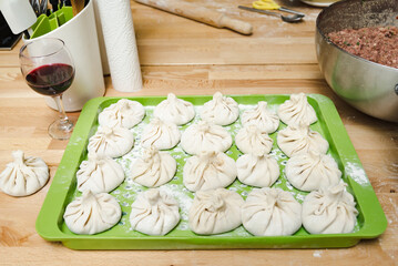Khinkali - Georgian dumplings on a green plastic tray ready to be boiled in hot water