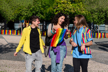 Young diverse friends walking on the street with the lgbt rainbow flag.