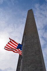 Low-angle view of American flag waving in front of the Washington Monument, Washington DC
