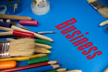 Overhead shot of school supplies with Business text. Brushes, pencils, artistic tools. Art And Craft Work Tools.