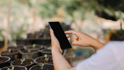 Woman Use of mobile phone with agricultural technology.