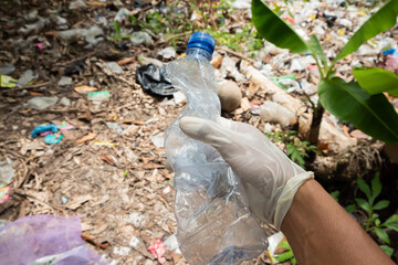 Obraz premium People picking up plastic bottles into garbage bags. agriculture and climate change, microplastic waste. food and plastic packaging industry
