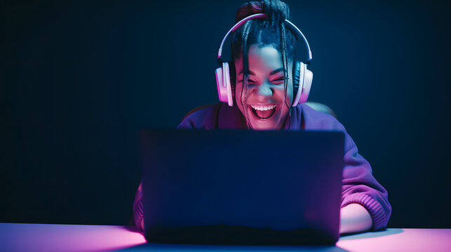 Cheerful female gamer winning an online game on a laptop