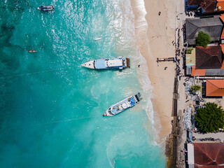 Aerial shoreline view of Jungutbatu beach at Nusa Lembongan with tourist speedboat anchored. One of travel destinations close to Bali island, Indonesia.