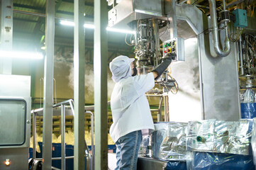 Female worker in a ketchup factory Controlled automatic aseptic filling machine filling ketchup...