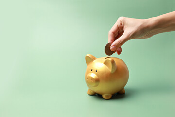 Woman hand putting money coin into piggy bank for saving
