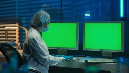 A doctor typing on a computer keyboard with green screen. Template place for your text or image,...