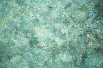 Green background from decorative plaster with abstract spots. Unusual green wall texture with beautiful patterns, creative surface background. Front covering for facing of buildings.