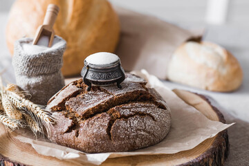Fresh delicious bread close-up and salt. Freshly baked sourdough bread with a golden crust on a wooden board. The context of a bakery with delicious bread. Confectionery products.