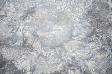 Obraz premium Gray background of decorative plaster with abstract spots. Unusual silver wall texture with beautiful patterns, creative surface background. Dressing coating for building cladding.