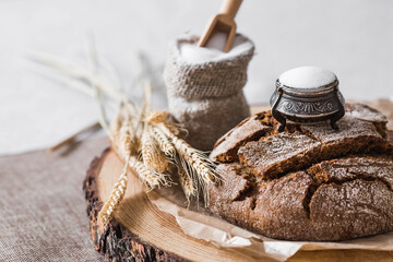 Fresh delicious bread close-up and salt. Freshly baked sourdough bread with a golden crust on a wooden board. The context of a bakery with delicious bread. Confectionery products.