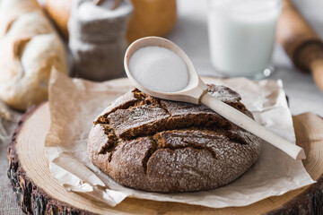 Fresh delicious bread close-up and salt. Freshly baked sourdough bread with a golden crust on a wooden board. The context of a bakery with delicious bread. Confectionery products.