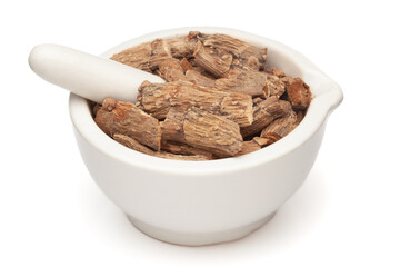 Closeup of Dry  Sweet flag or Vach (Acorus calamus) roots, in white ceramic mortar and pestle, isolated on white background.
