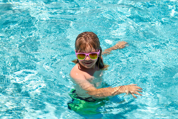 Child water toys. Children play in tropical resort. Child in swimming pool playing in water. Vacation and traveling with kids. Children play outdoors in summer. Kid with floating ring.