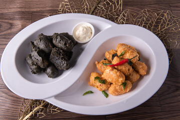 dou style deep fried crispy seafood beancurd black and white tofu in salted egg yolk sauce and mayonnaise sauce on wood table asian halal banquet appetiser snack salad menu 