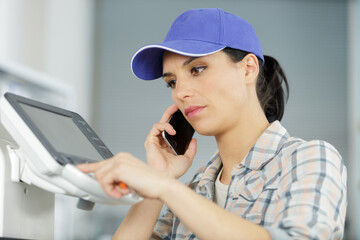 a woman on the phone fixing a printer