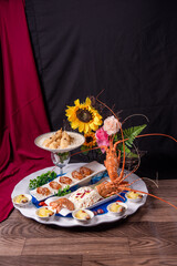 Naklejka na ściany i meble beautiful Deluxe Lobster Big cold Platter Combination with deep fried prawn honey chicken wing lobster salad herbal dim sum roll in flower plate decor on wood table asian banquet appetiser halal menu