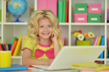 girl using laptop at desk at home