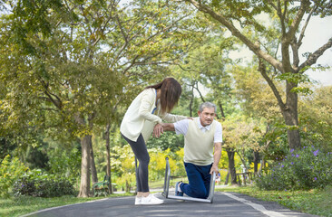 Obraz premium young woman caregiver is helping disability senior man fall due to practice walking with a walker.concept elderly care, health care, rehabilitation