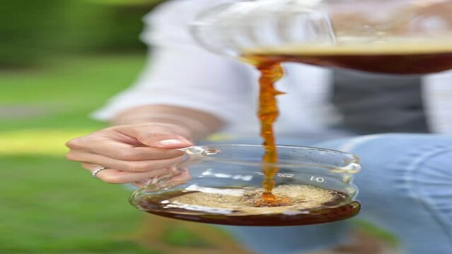 Person holding a glass of coffee