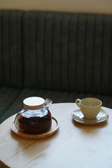 Cup tea and glass teapot on wooden table