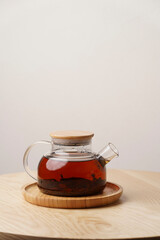 Glass teapot on wooden table, white  background