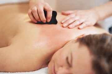 Fototapeta na wymiar Woman having a gua sha massage in salon