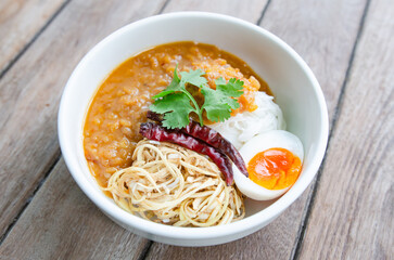 A wooden table with rice noodles and chili paste
