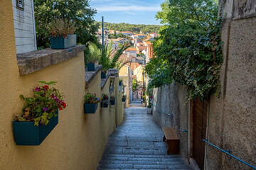 Typical croatian street on Mali Losinj with steps, houses and flowers, Croata