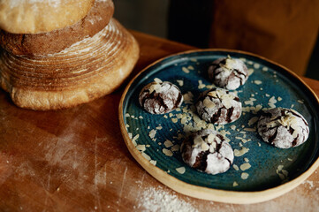 Closeup freshly made cookies on plate and bread on wooden table
