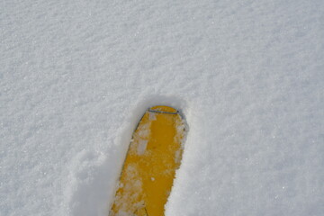 yellow ski tip in fresh powder snow background