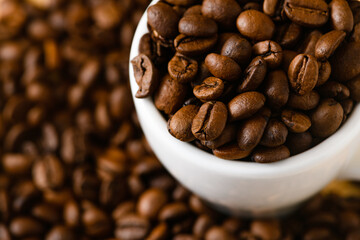 Coffee brown background with many beans and cup, top view, morning drink beverage natural ingredient