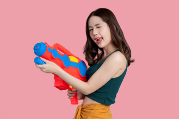 Asian woman using water guns playing songkran festival, isolated background.