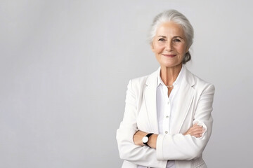 Portrait of a confident elder businesswoman in a suite on the solid white background. Copy space around.