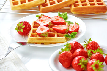 Breakfast with freashly baked belgian waffles on white table. Cooking concept. Healthy dessert, summer time