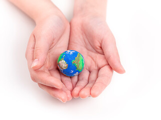 A child holds a small plasticine globe with both hands.