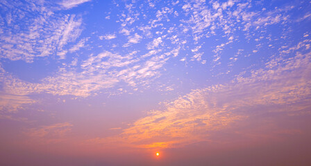 Beautiful Sunset Sky Background with altocumulus clouds and orange sunlight on dusk blue sky in evening time